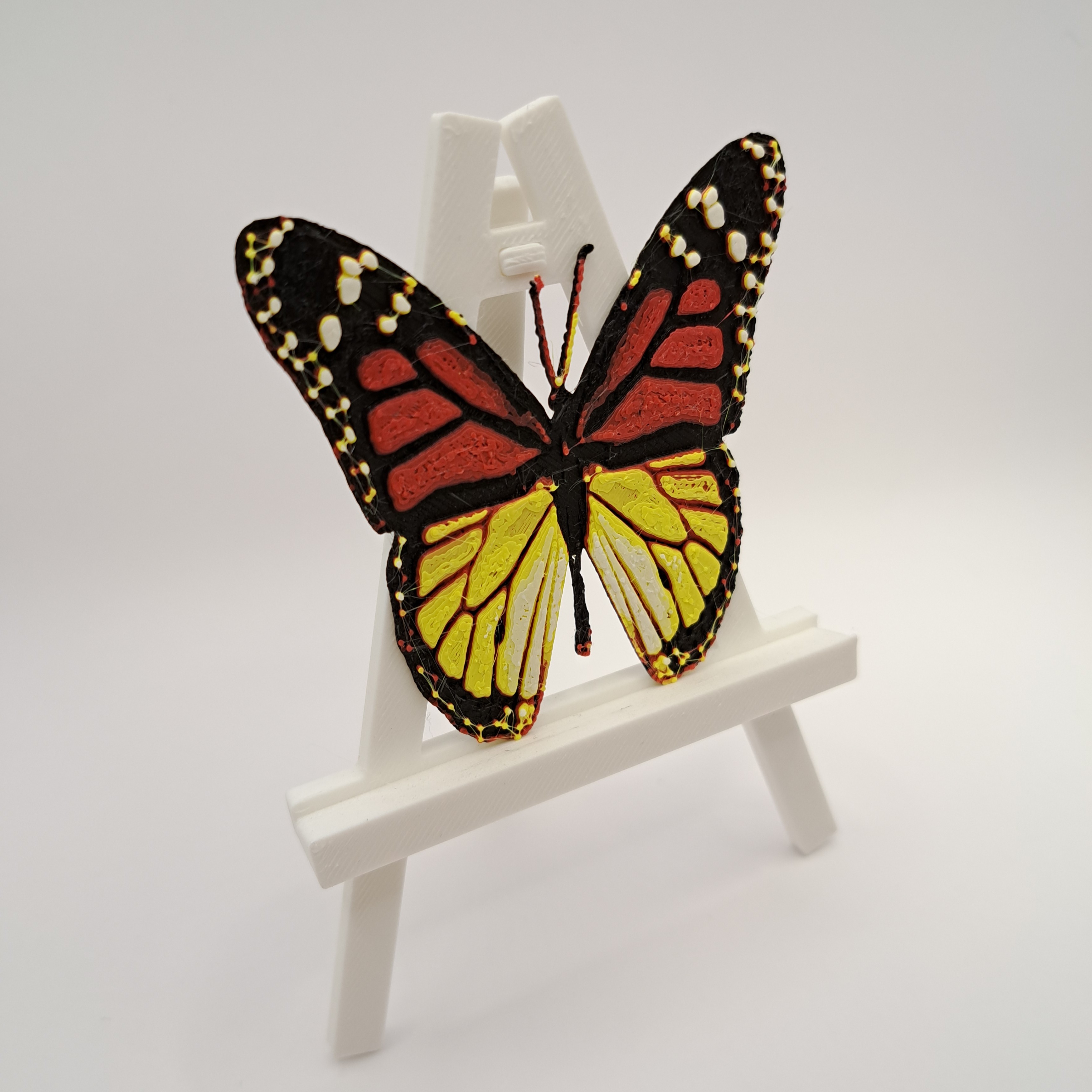 Papillon imprimé en plusieurs couleurs par une machine 3D